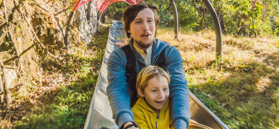 Father and son riding slide